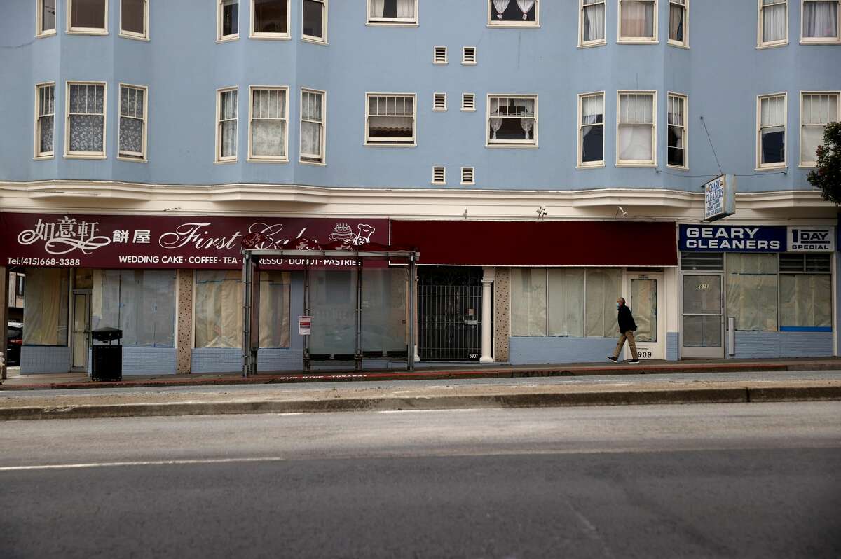 A pedestrian walks by closed businesses along Geary Boulevard on April 16, 2021, in San Francisco. 