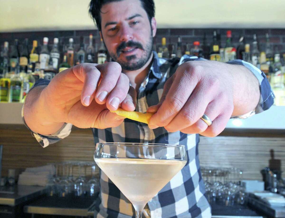 John Ginnetti, owner of 116 Crown in New Haven, finishes his classic martini with a twist in 2010. To protect staff and customers from the spread of COVID-19, Ginnetti is closing 116 Crown and Meat & Co., his other restaurant, until next week.