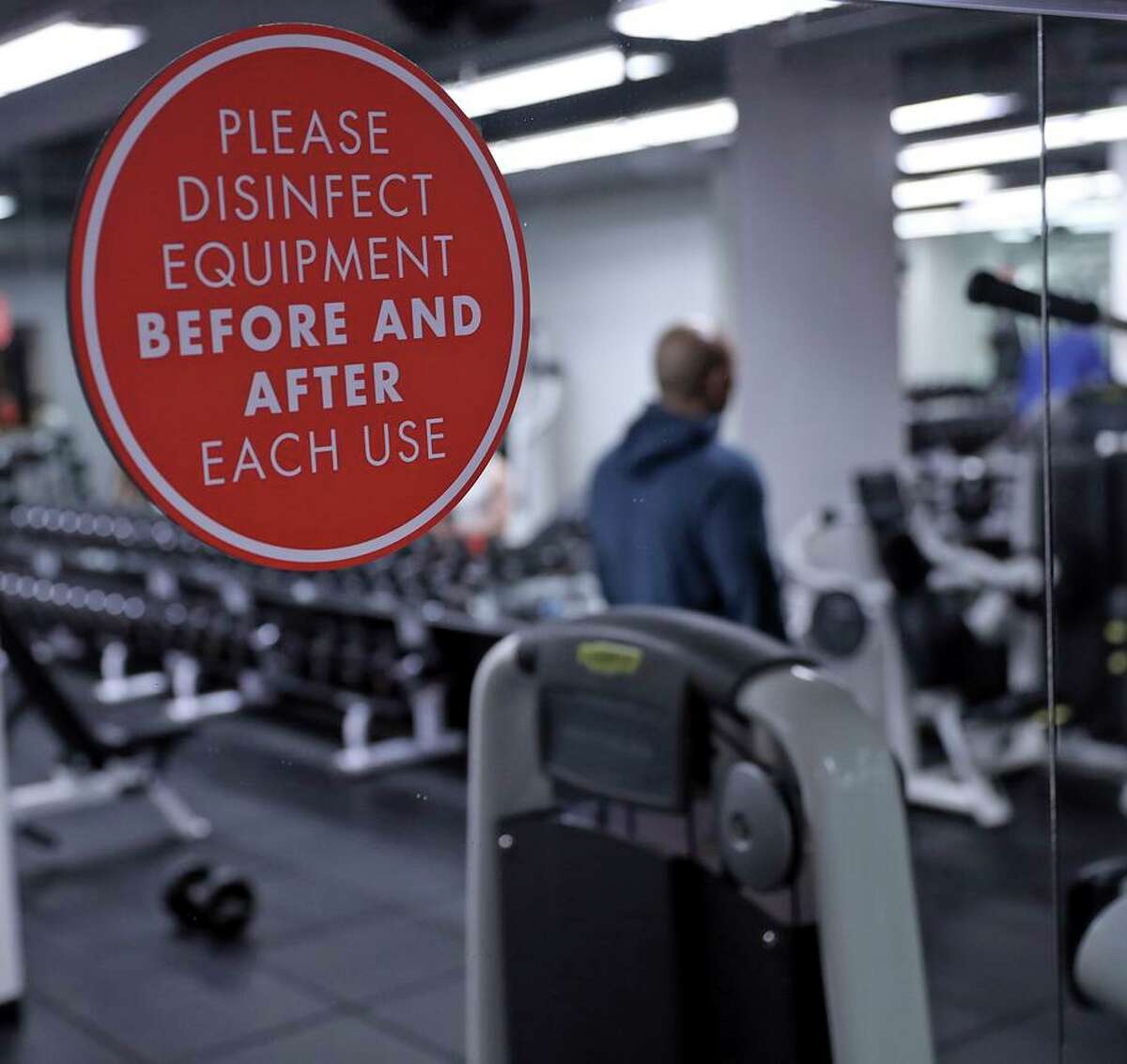 Sign reminding members to disinfect equipment after each use at Fitness SF on Fillmore Street in San Francisco, Calif., on Wednesday, December 29, 2021. Starting on December 30th, Fitness SF members will be required to wear masks.