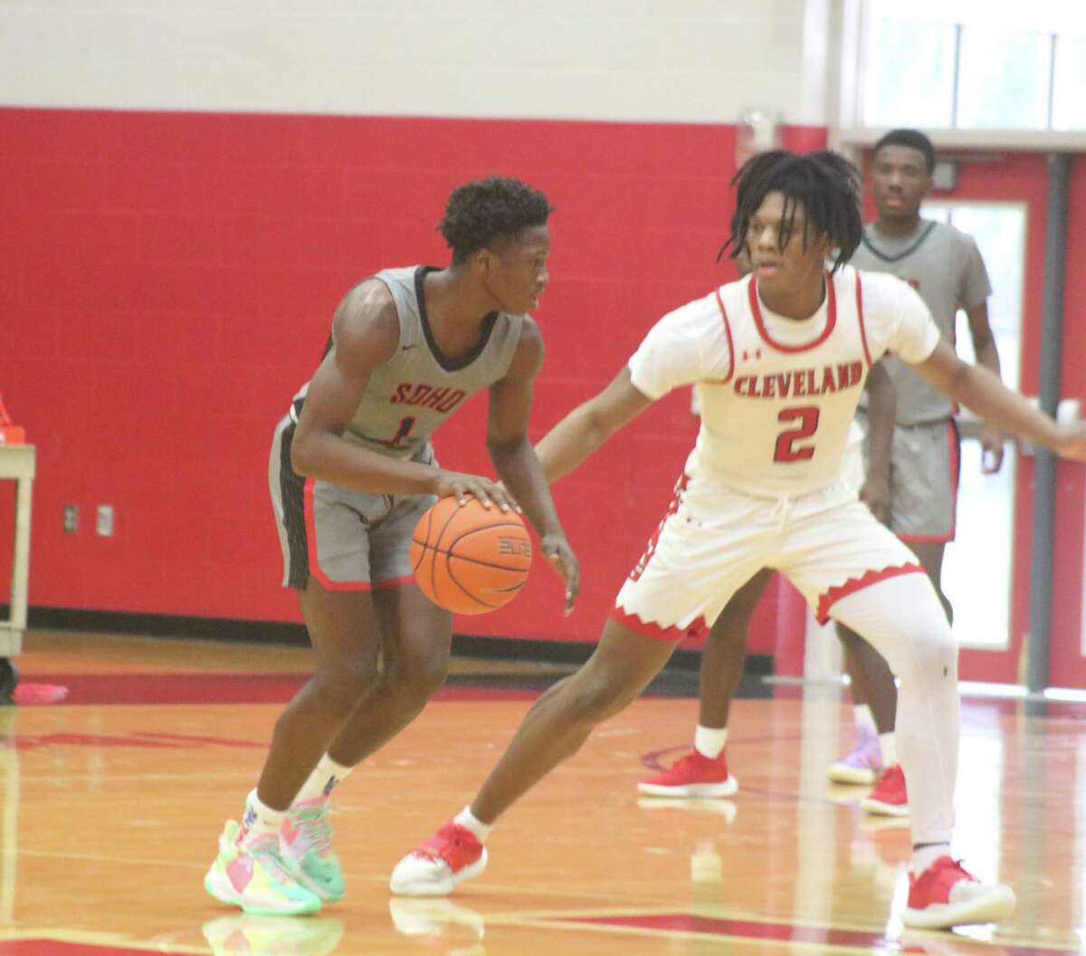 South Houston's Josh Larry confronts Devontae Robertson of Cleveland in their Medina Classic showdown Wednesday. Robertson scored 14 second-half points, but the Trojans held on to win 44-39.