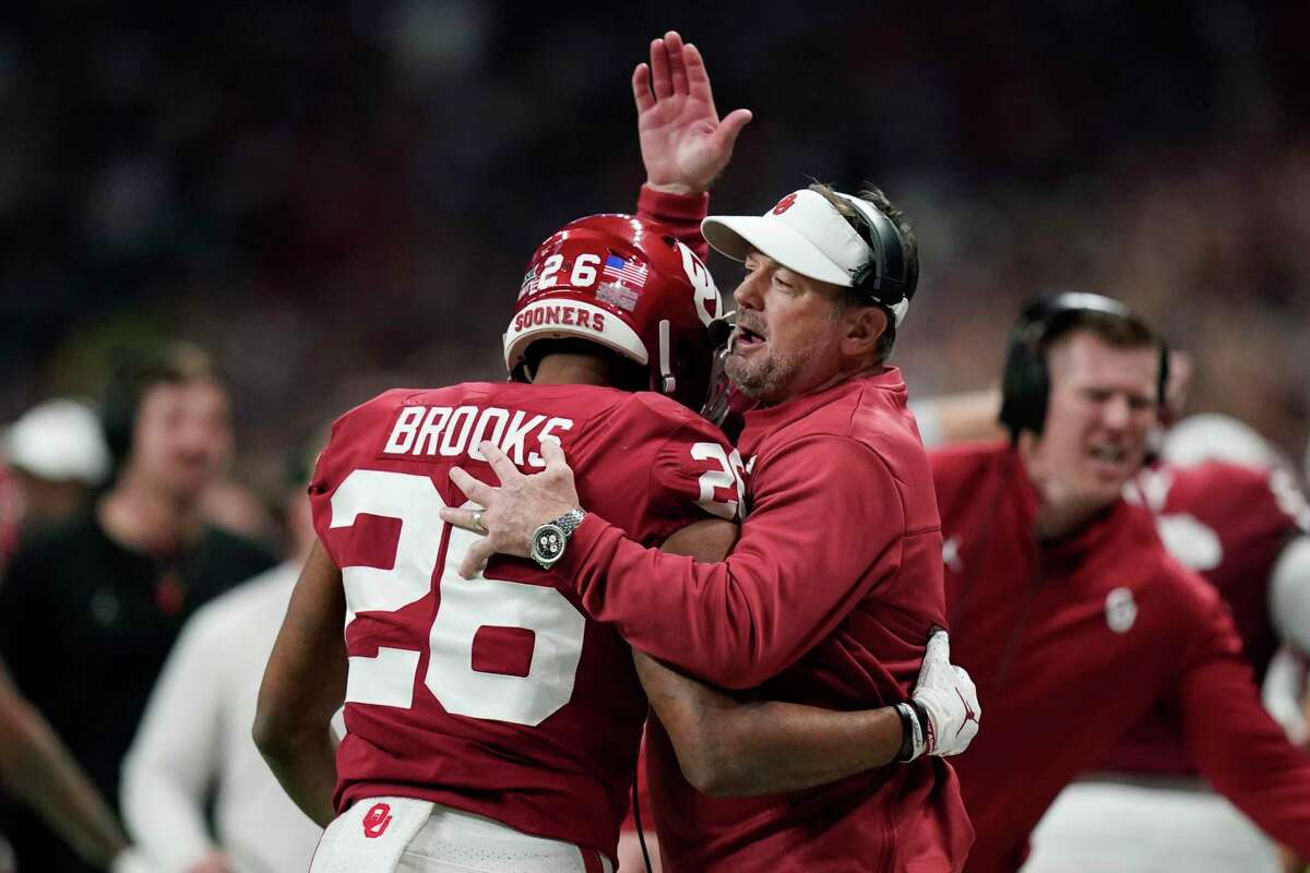 Oklahoma interim coach Bob Stoops, right, celebrates with running back Kennedy Brooks (26) after his touchdown against Oregon during the first half of the Alamo Bowl NCAA college football game, Wednesday, Dec. 29, 2021, in San Antonio. (AP Photo/Eric Gay)