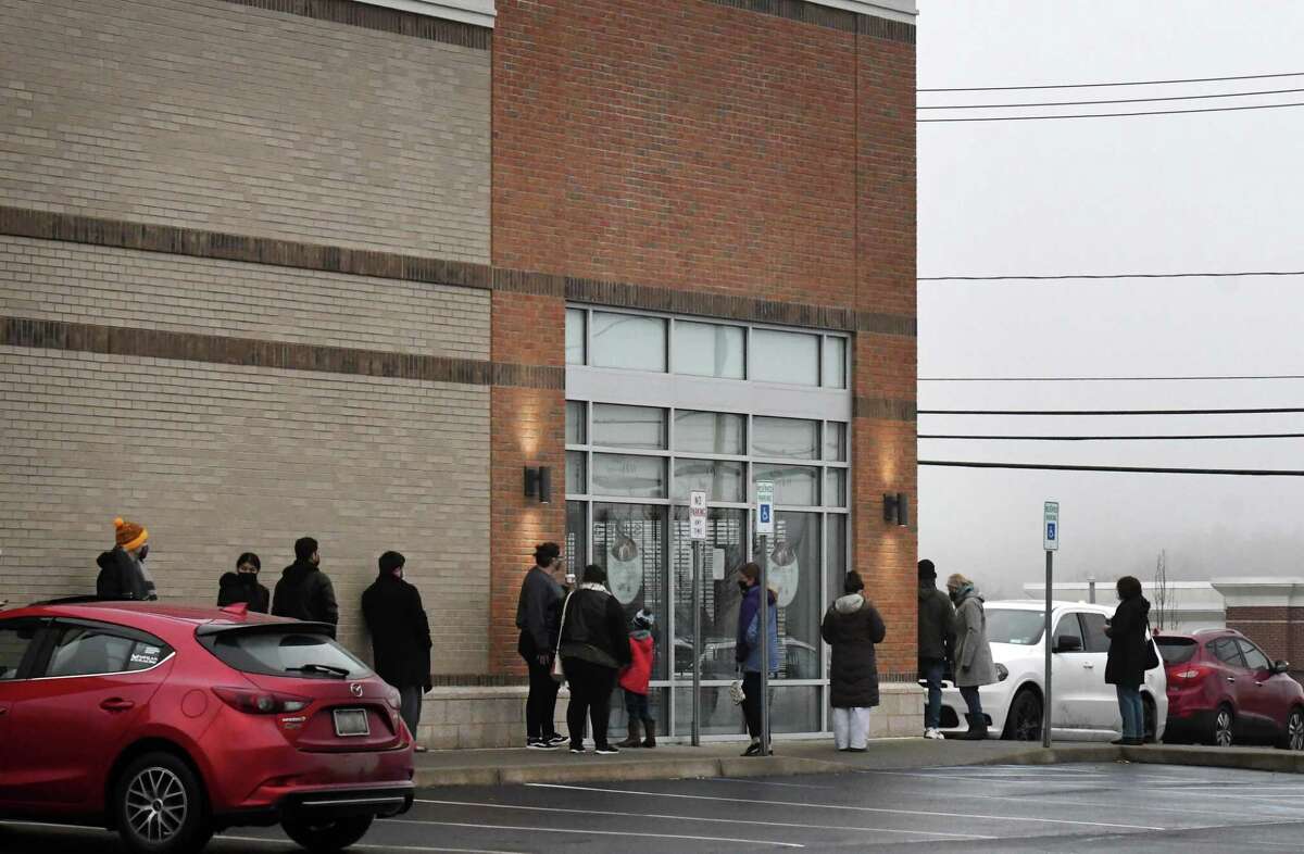 People stand in line at the WellNow Urgent Care on Balltown Rd. where testing for COVID-19 is offered on Thursday morning, Dec. 30, 2021, in Niskayuna, N.Y.