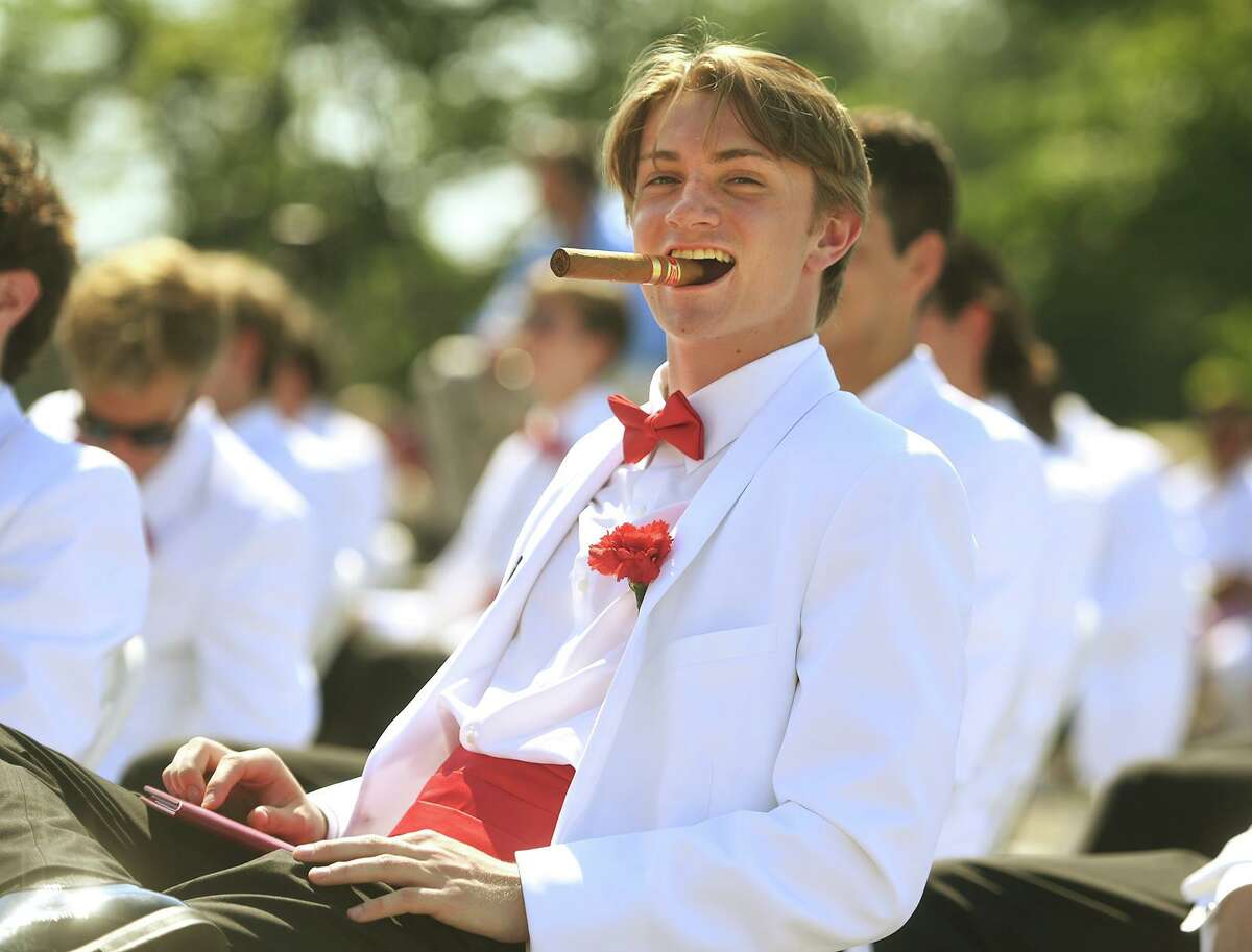 Graduate Philip Gallagher pulls out a stogie during the Fairfield Prep graduation in Fairfield, Conn. on Sunday, June 6, 2021.
