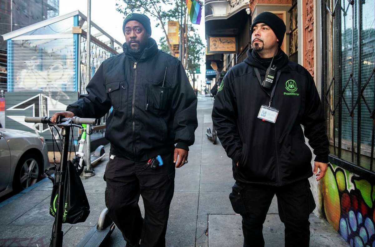 城市炼金术监督员迪翁·布里奇斯(左)和何塞·奥卡西奥走在Tenderloin的街道上，努力清理社区。