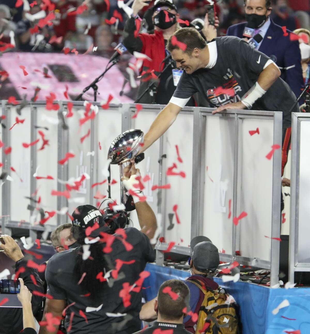 Tampa Bay Buccaneers quarterback Tom Brady (12) hands the Lombardi Trophy to Tampa Bay Buccaneers nose tackle Vita Vea (50) while they celebrate the Buccaneers' 31-9 win over the Kansas City Chiefs in Super Bowl LV Sunday, February 7, 2021 in Tampa, Florida. 