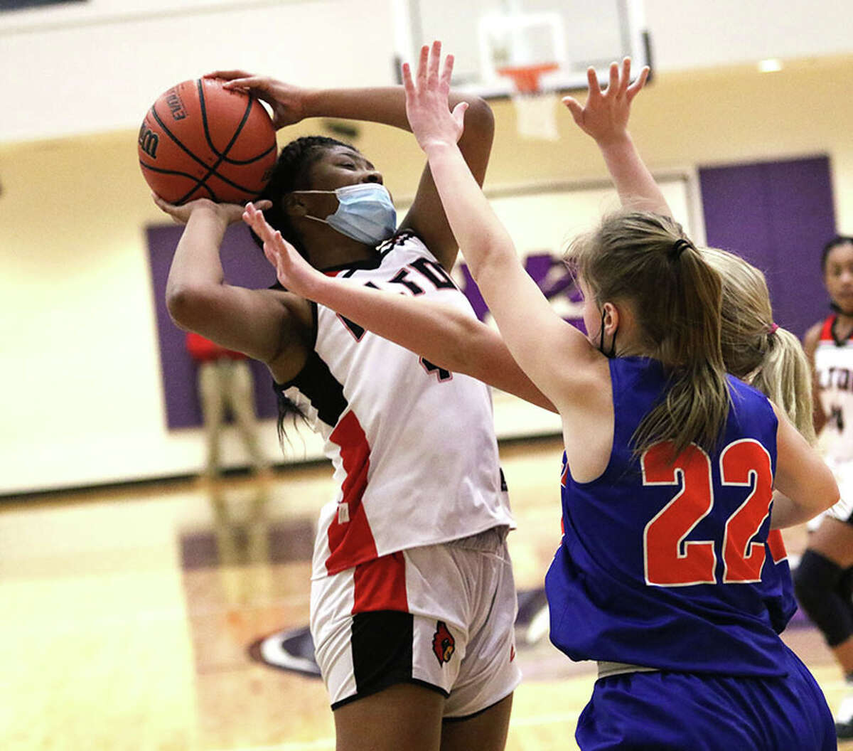 Alton's Jarius Powers (left) shoots over Okawville's Raelyn Obermeier (22) in Wednesday's title game at the 43rd Mascoutah Invitational girls basketball tournament in Mascoutah.