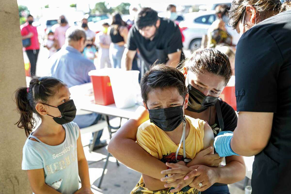 Six-year-old Emily Mancha watches her mother Amelia Tovar comfort her 8-year-old brother Hector Mancha as he receives a COVID-19 vaccine at a pop up vaccine clinic down the street from the McAllen-Hidalgo-Reynosa International Bridge in Hidalgo, Texas, Thursday morning, Nov. 11, 2021. The family crossed into the United States to visit Tovar’s sister Brianda Tovar Rodriguez and decided to get the children vaccinated at the free walk-up clinic.