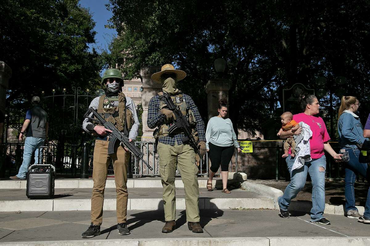 Armed demonstrators stand outside the Texas State Capitol in Austin on Sunday, Jan. 17, 2021. The men gave their names as Crispy, left, who is with the Texas Guerrillas Militia, and Stack Shack, who is with the Boogaloo movement.