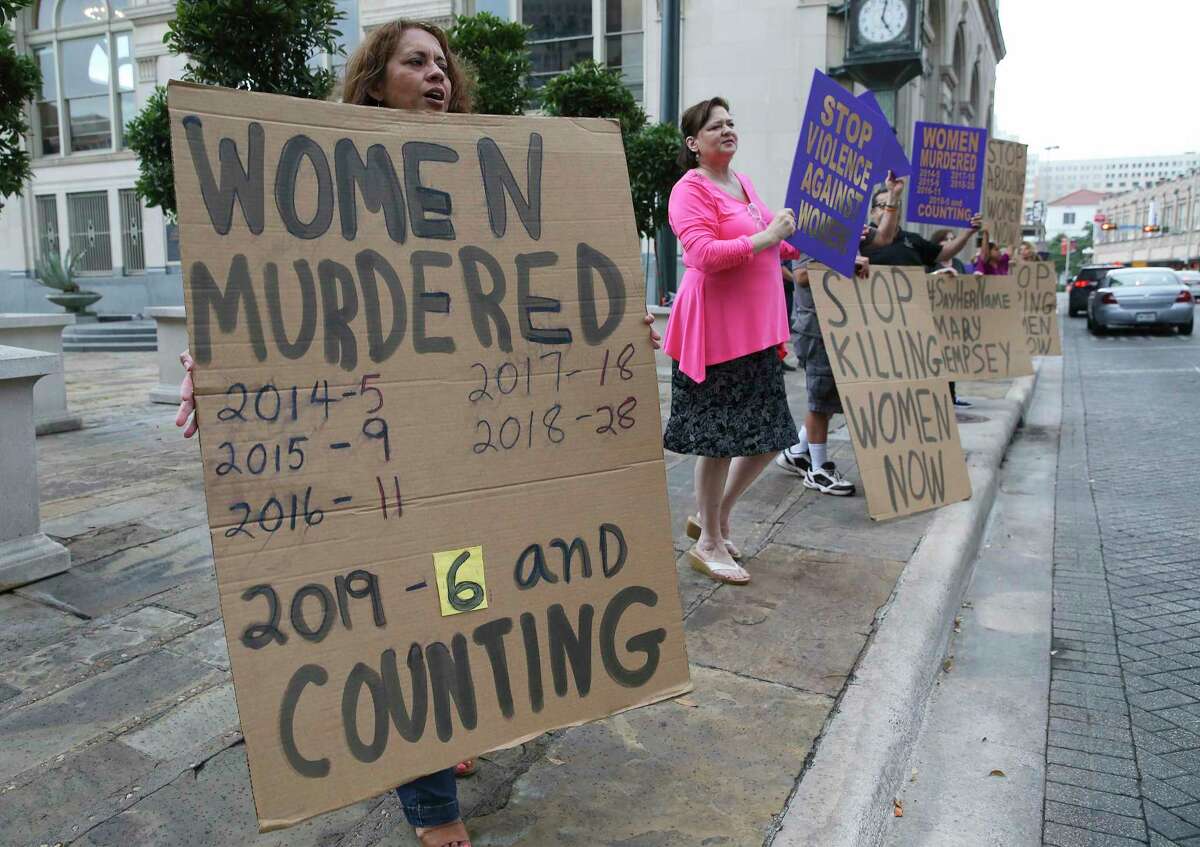 Ellie De La Cruz (left) carries a sign with a count of women murdered in San Antonio as she joins the P.E.A.C.E. Initiative - a San Antonio organization that seeks to end family violence - during a rally near City Hall on Wednesday, May 1, 2019 to call attention to domestic violence accusations against mayoral hopeful Greg Brockhouse. About two dozen people held signs to denounce domestic violence.