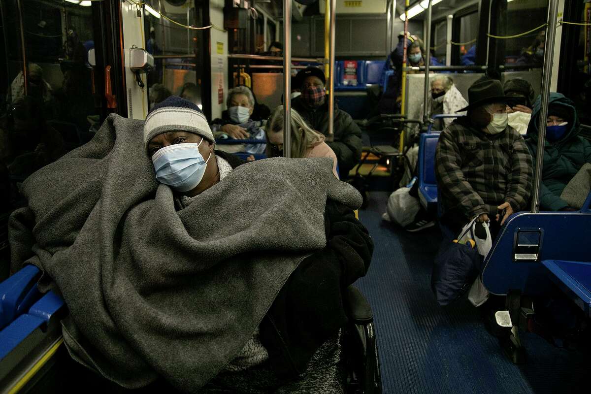Deidra Anderson, 57, a resident of Fair Avenue Apartments, waits with fellow residents on a VIA bus late Tuesday night to be transported to the Grand Hyatt hotel downtown on Feb. 16, 2021 in San Antonio. The apartments had been without electricity and water since Sunday except for the elevator, entrance and some hallways.