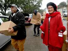 Volunteers, including (from left) Terrell Parker, Ricky Anderson and Deborah Freeman, help distribute holiday food boxes filled with produce and essentials and turkeys during a Southeast Texas Food Bank holiday distribution Monday in Port Arthur. Freeman dressed for the occasion, having come to the event from her morning prison ministry work. "Christmas is my favorite time," she said, adding, "I just love Port Arthur, so I volunteer whenever I can." In all, 500 turkeys and boxes were given out to help families this holiday season. Photo made Monday, December 20, 2021 Kim Brent/The Enterprise