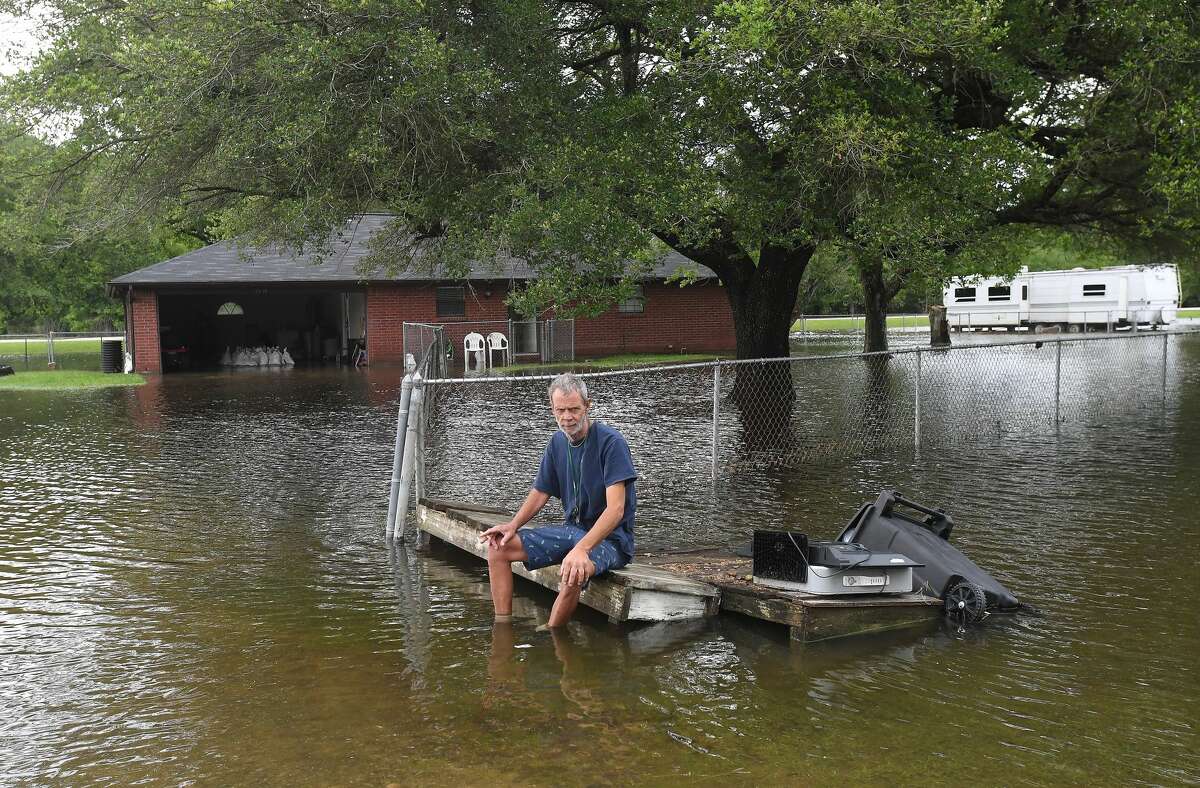 David O'Pry takes a break from moving articles out of his sister's flooded home in Fannett Tuesday. The area received over a foot of rainfall Monday, flooding area bayous and several yards and homes. Photo made Tuesday, May 18, 2021 Kim Brent/The Enterprise