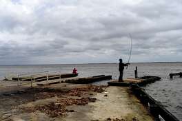 Gilbert Delgado and Jodie Bowen of Orange spend time fishing at Mesquite Point Monday near a boat ramp that was damaged during Tropical Storm Harvey. Jefferson County is moving forward with plans to repair the ramp using a grant from Texas Parks and Wildlife. Photo made Monday, March 22, 2021 Kim Brent/The Enterprise
