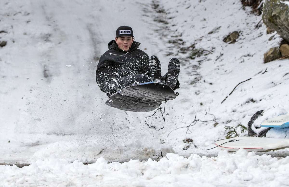 Matthew Eastman, 15, sleds off a jump he built at the end of his driveway after a winter storm blanketed the western part of the nation. A storm system moving into west-central Illinois this weekend is expected to bring ice and snow, as well as bitter cold.
