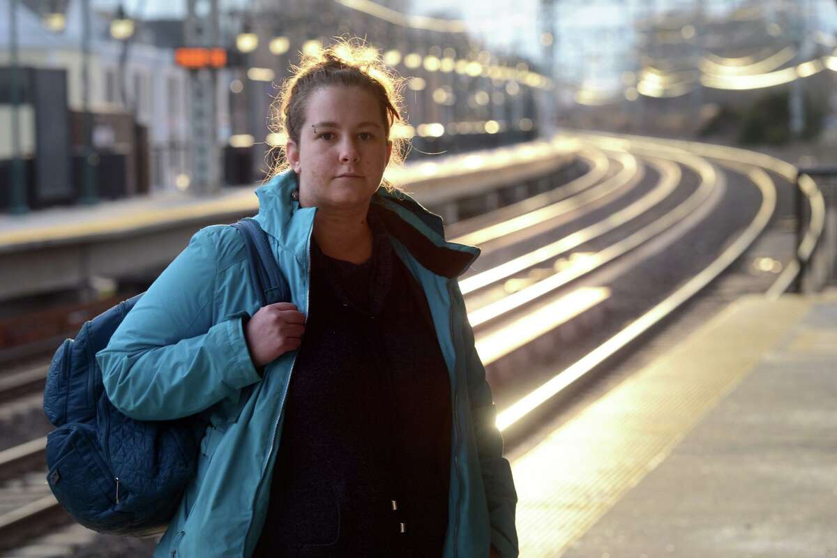 Emily Bump, a Metro-North commuter, poses on the platform of the rail station in Milford, Conn., Dec. 28, 2021.