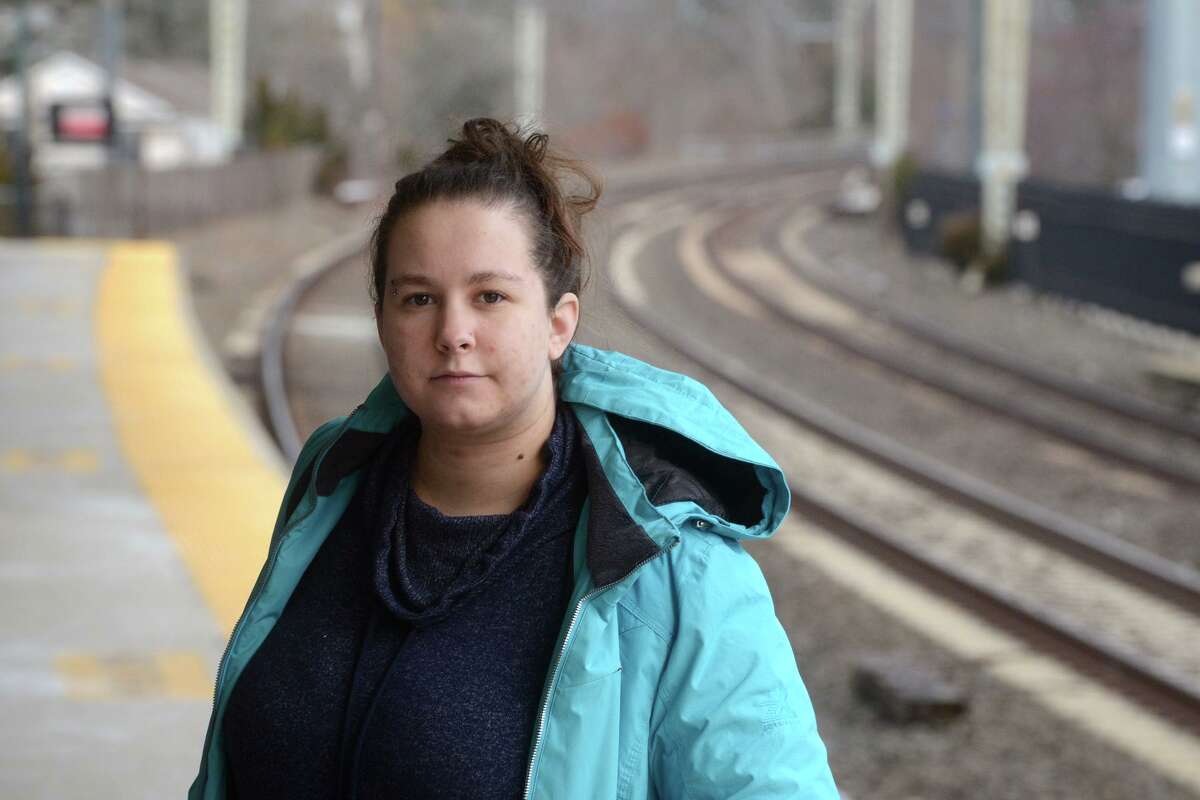 Emily Bump, a Metro-North commuter, poses on the platform of the rail station in Milford, Conn., Dec. 28, 2021.