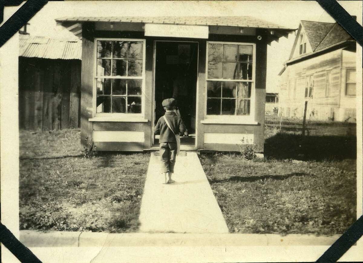 A barefoot boy walks on the new sidewalk leading into what was known as the world's smallest library in Crosby, Texas. The 9-foot by 12-foot structure was formerly a gas station and remodeled for the community's first library.