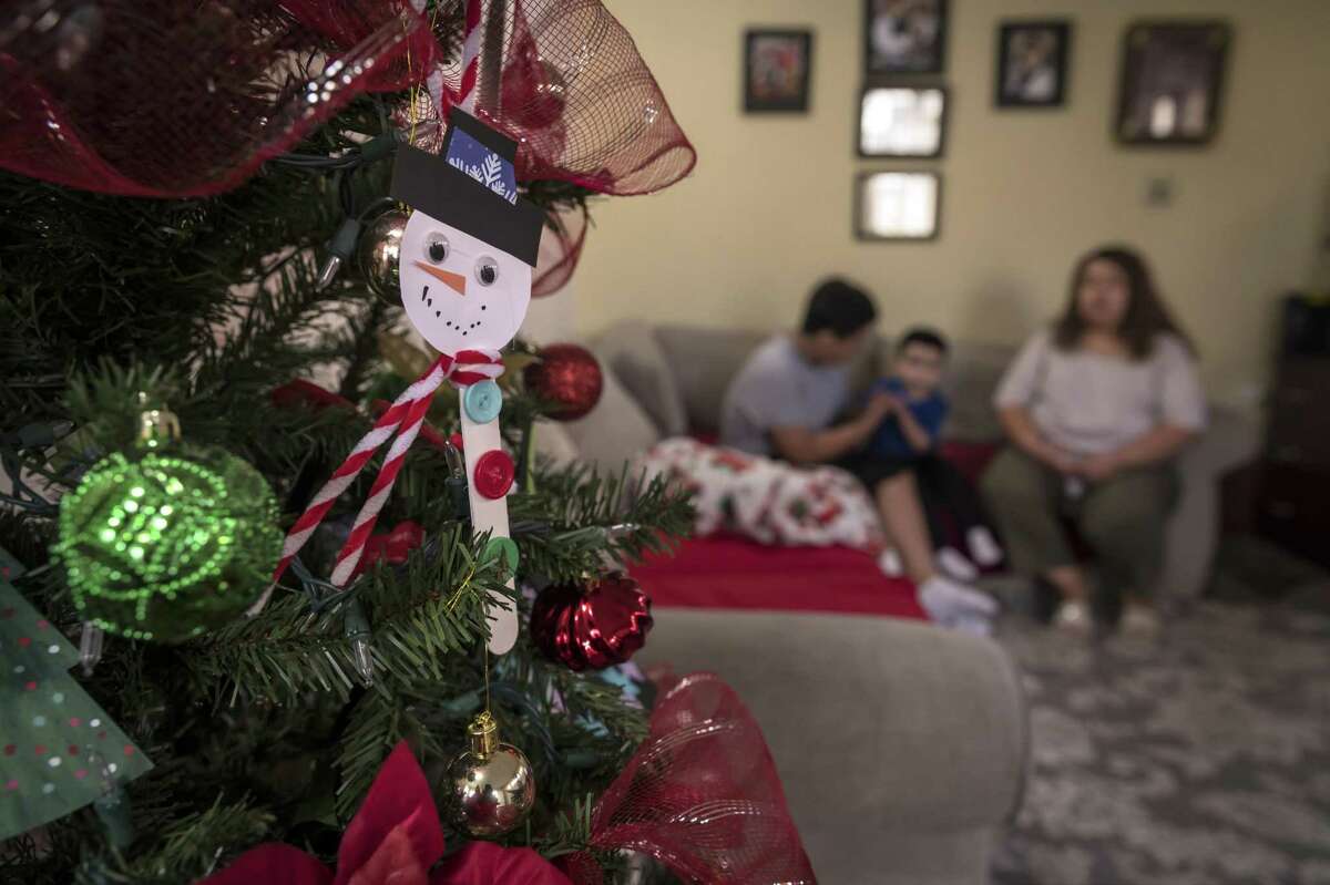 Christmas decorations hang on a tree as Ana sits with sons Alejandro, 14, and Mateo, 4, in their garage apartment in Oakland. Alejandro struggled when he first arrived in Oakland as a 9-year-old, speaking no English and fearing he would be separated from his mother. Today he is excelling at school and was named to Oakland Unified’s Latino Student Honor Roll in 2020.
