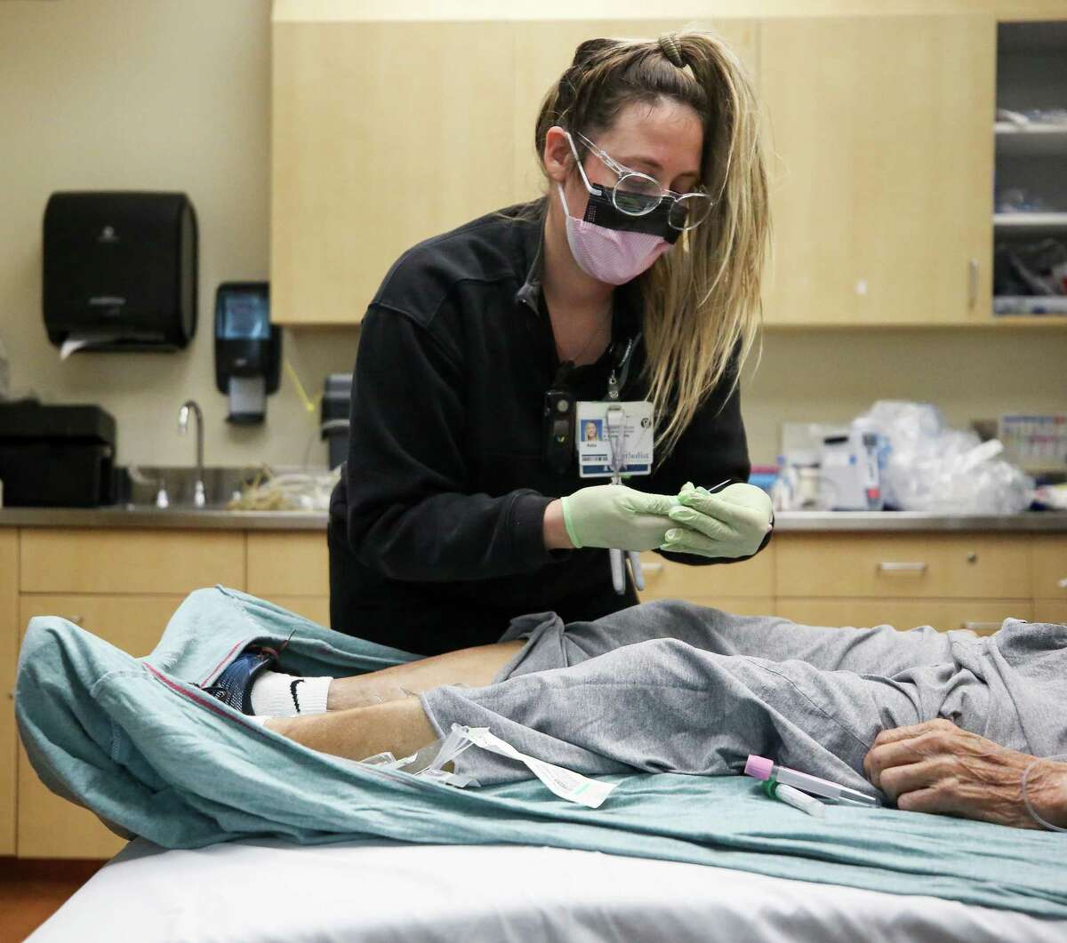 Registered nurse Kate Boback checks in on a patient who had just been brought into the Emergency Department by Houston Fire paramedics at Houston Methodist Hospital on Tuesday, Dec. 21, 2021, in Houston.