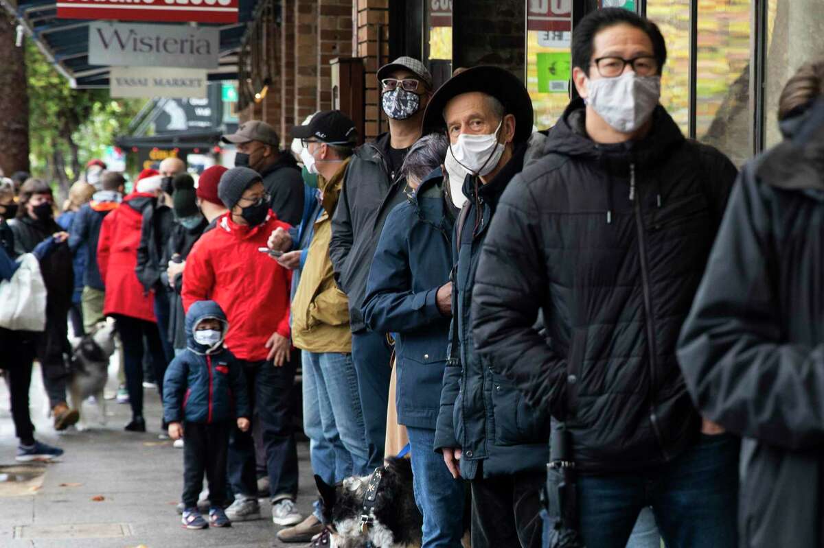 Customers wear masks in line at Ver Brugge Meat-Fish Poultry along College Avenue in Oakland.