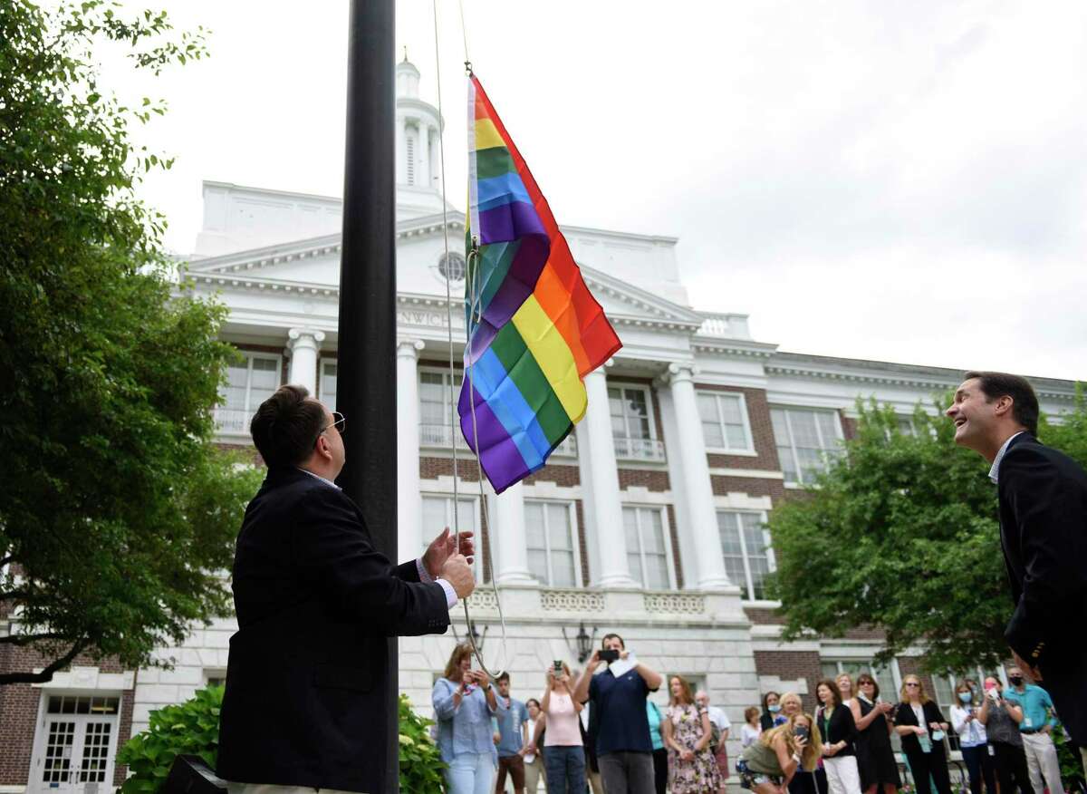 Former Selectman Drew Marzullo raises a rainbow flag during the Pride Month LGBTQ+ ceremony at Town Hall in Greenwich, Conn. Thursday, June 10, 2021. Former Selectman Drew Marzullo, the town's only openly-gay Selectman, joined First Selectman Fred Camillo and U.S. Rep. Jim Himes, D-Conn., to acknowledge the progress that has been made in acceptance of the LGBTQ+ community while noting that there is still much work to be done.