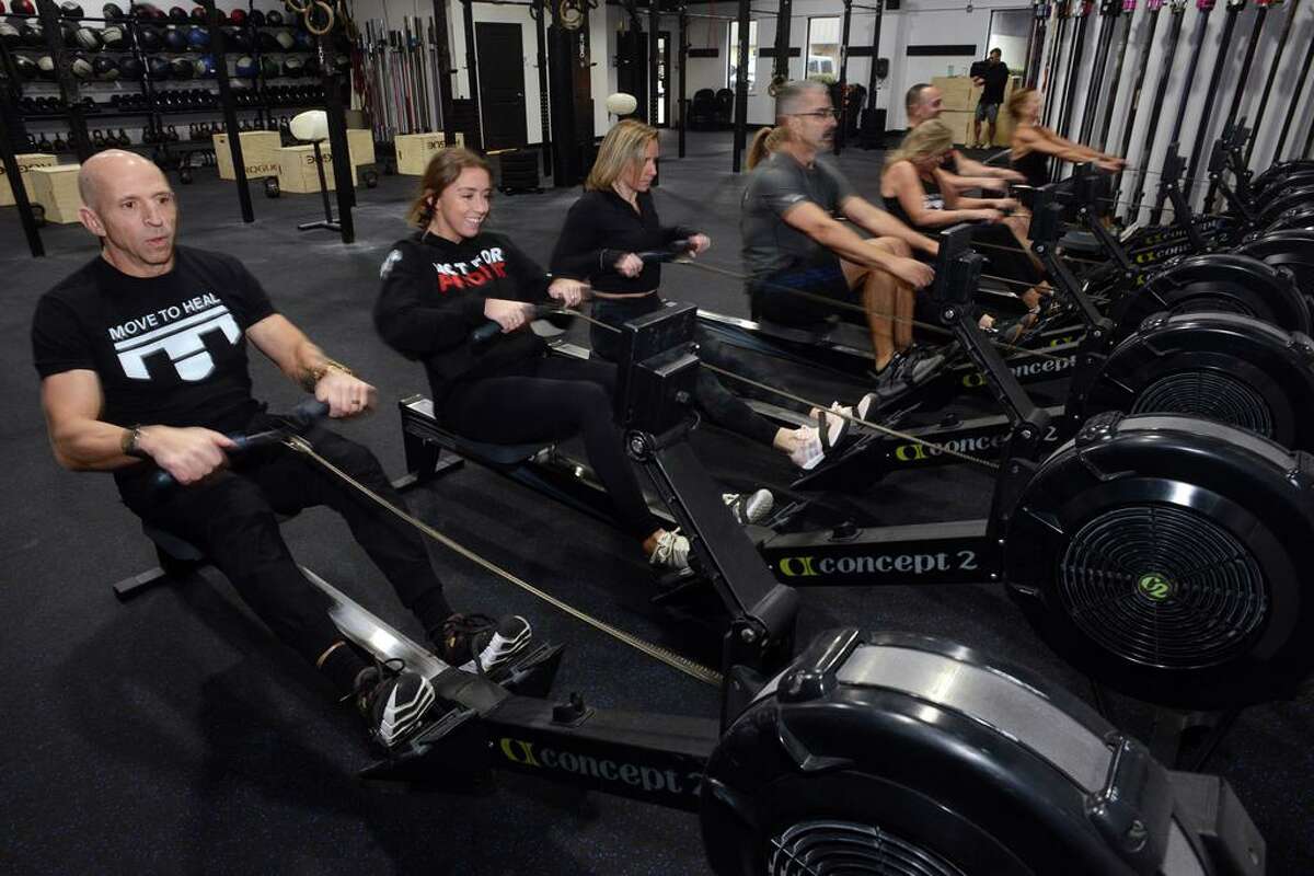 Ethan Hershman, left, leads a Move to Heal group fitness exercise class at Shoreline CrossFit, in Branford, Conn. Dec. 27, 2021.