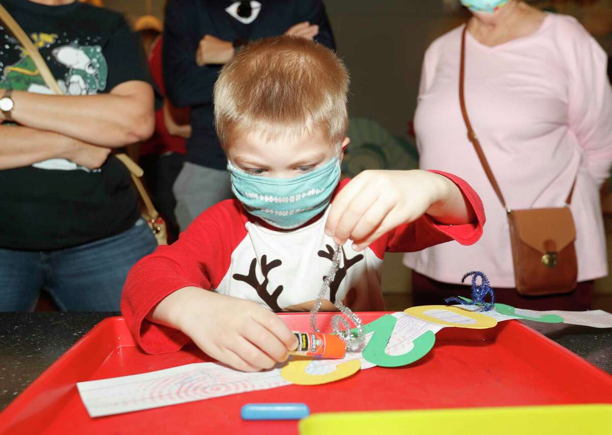 James Smooth works on a 2022 headband as visitors to The Woodlands Children’s Museum rang in the New Year, Friday, Dec. 31, 2021, in The Woodlands.