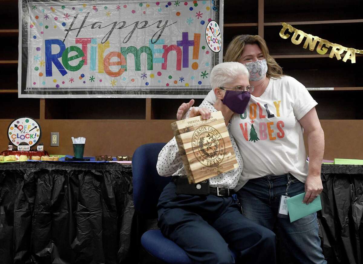 Jefferson County Clerk Theresa Goodness gets a hug from long-time coworker Becky Bertrand as she opens gifts from staff during a small office party celebrating her retirement. Photo made Tuesday, December 21, 2021 Kim Brent/The Enterprise