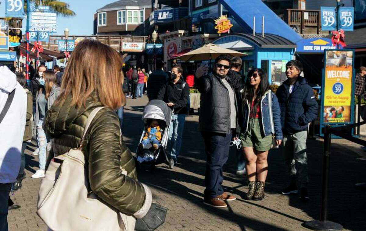 A family takes a picture at San Francisco’s Pier 39. The city canceled New Year’s Eve fireworks.