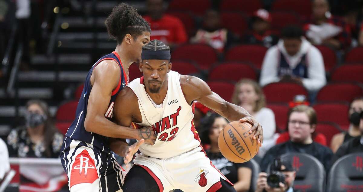 Miami Heat forward Jimmy Butler (22) battles against Houston Rockets guard Jalen Green (0) during the first half of an NBA basketball game at the Toyota Center, Friday, Dec. 31, 2021 in Houston.