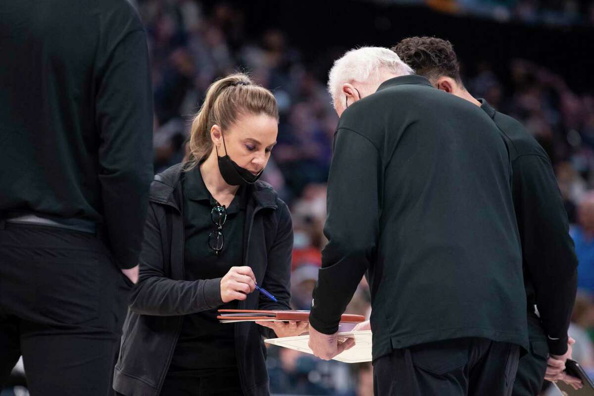 San Antonio Spurs assistant coach Becky Hammon works with coach Gregg Popovich during the second half of the team's NBA basketball game against the Memphis Grizzlies on Friday, Dec. 31, 2021, in Memphis, Tenn. (AP Photo/Nikki Boertman)