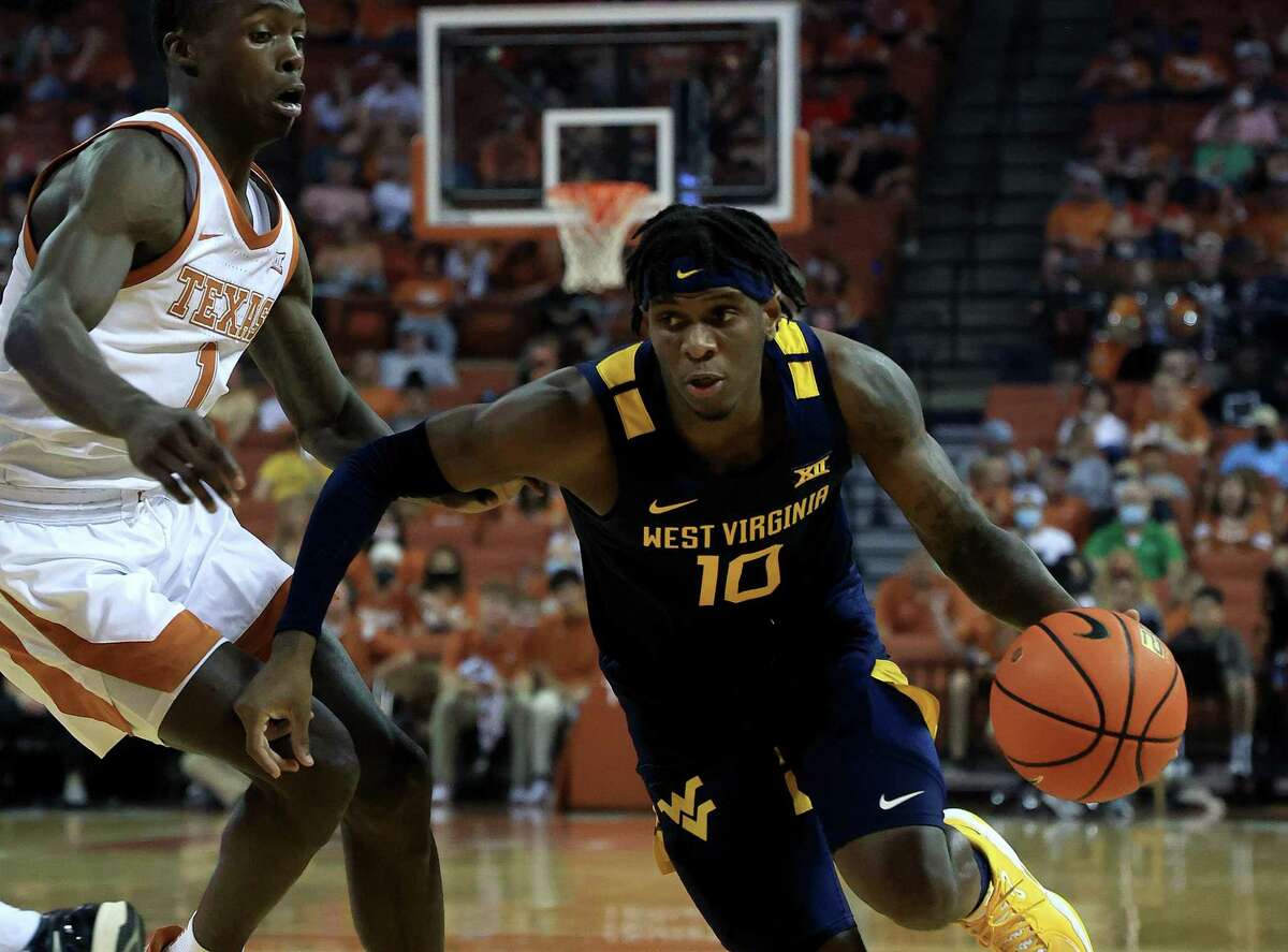 Malik Curry (10) of the West Virginia Mountaineers drives against Andrew Jones (1) of the Texas Longhorns at The Frank Erwin Center on Saturday, Jan. 1, 2022 in Austin, Texas. (Chris Covatta/Getty Images/TNS)