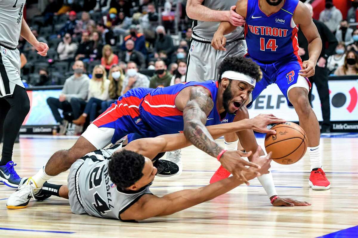 Saddiq Bey (41) of the Pistons and Devin Vassell (24) of the Spurs go for a loose ball in overtime at Little Caesars Arena on Saturday, Jan. 1, 2022 in Detroit.