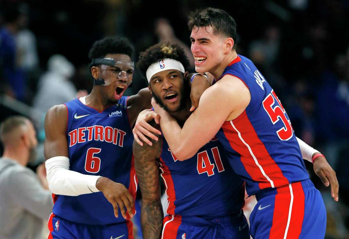 Pistons forward Saddiq Bey (41) celebrates with guard Hamidou Diallo (6) and center Luka Garza, right, after sinking a 3-point shot to defeat the Spurs in overtime Saturday, Jan. 1, 2022, in Detroit.