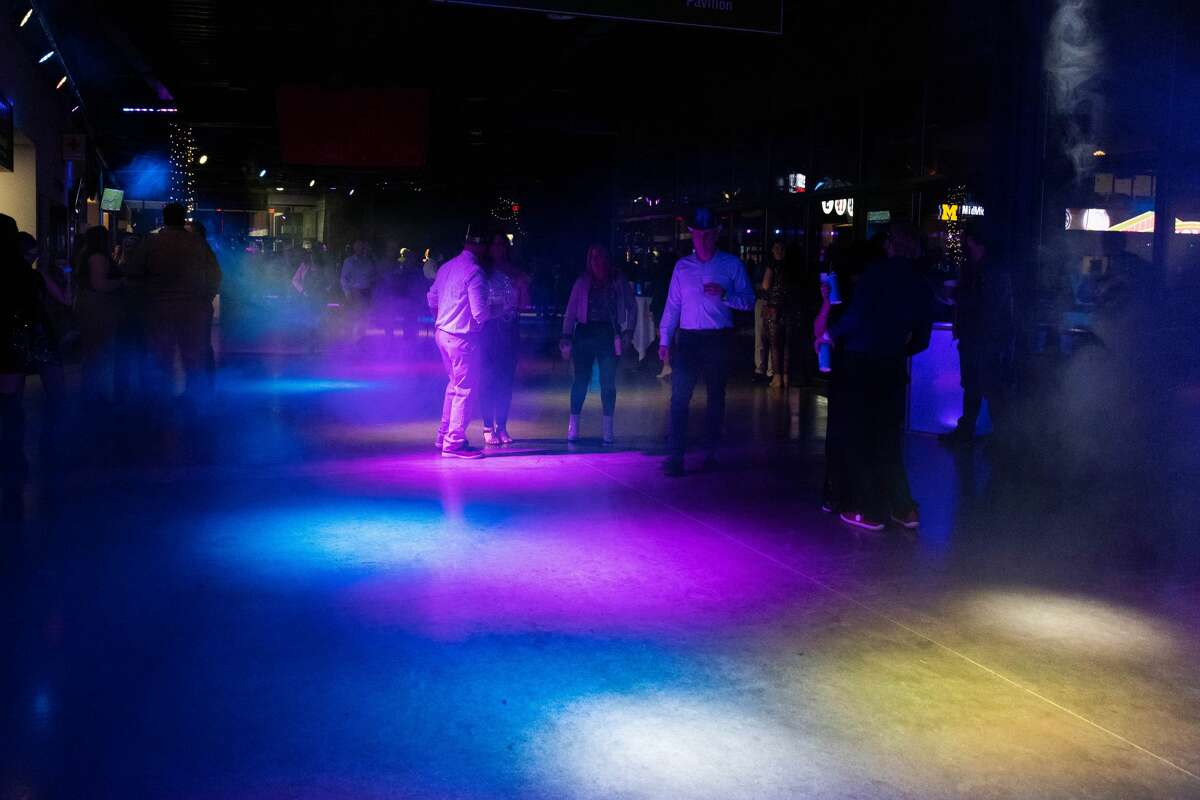 Attendees of the Midnight on Main New Year's Eve event dance to live music, drink and party Friday, Dec. 31, 2021, at Dow Diamond.   
