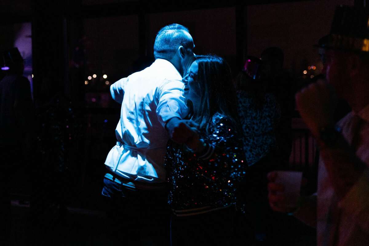 Attendees of the Midnight on Main New Year's Eve event dance to live music, drink and party Friday, Dec. 31, 2021, at Dow Diamond.  