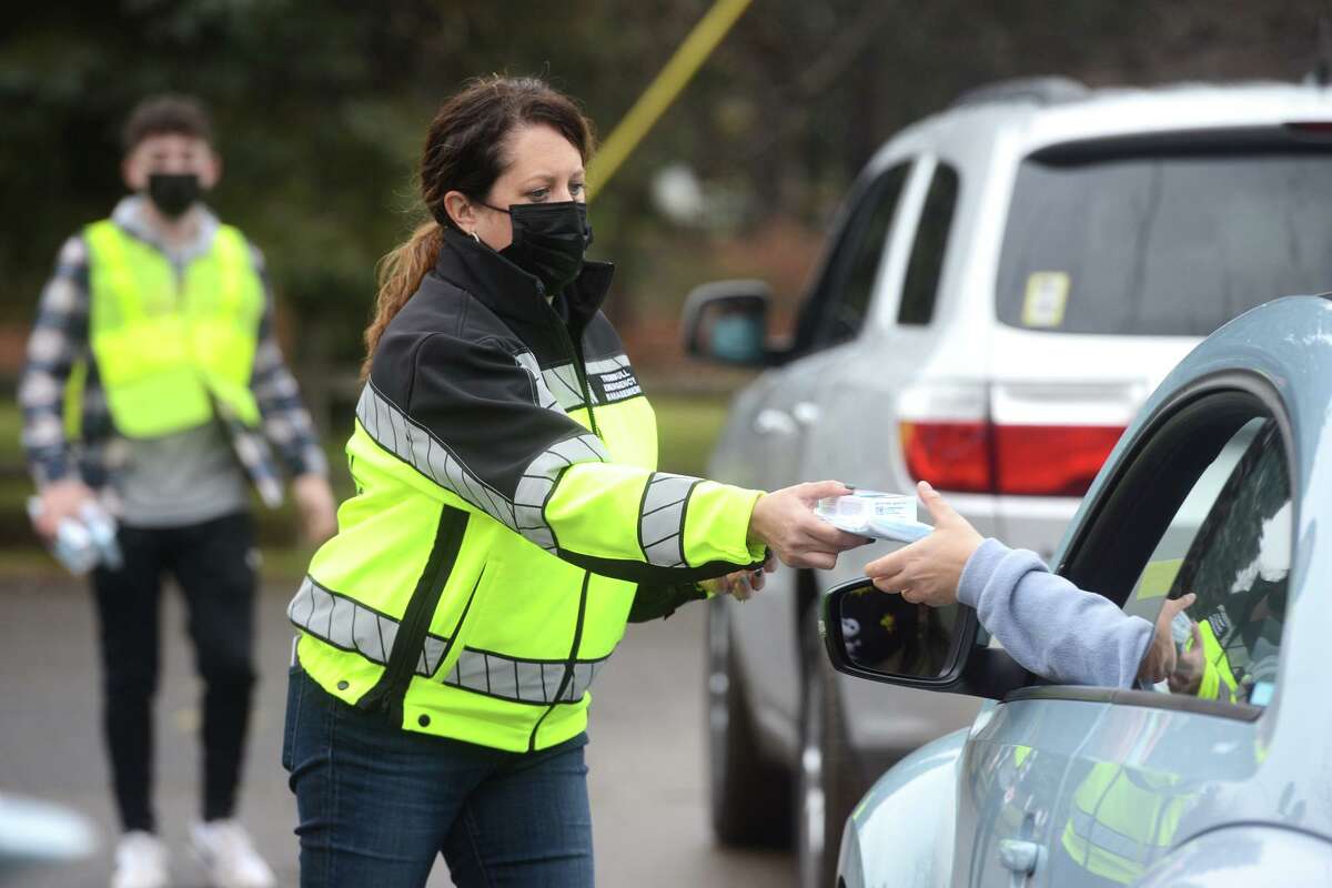 Emergency Management Director Megan Murphy hands out COVID-19 home test kits during a during drive-thru pickup at Unity Park, in Trumbull, Conn. Jan. 2, 2022.
