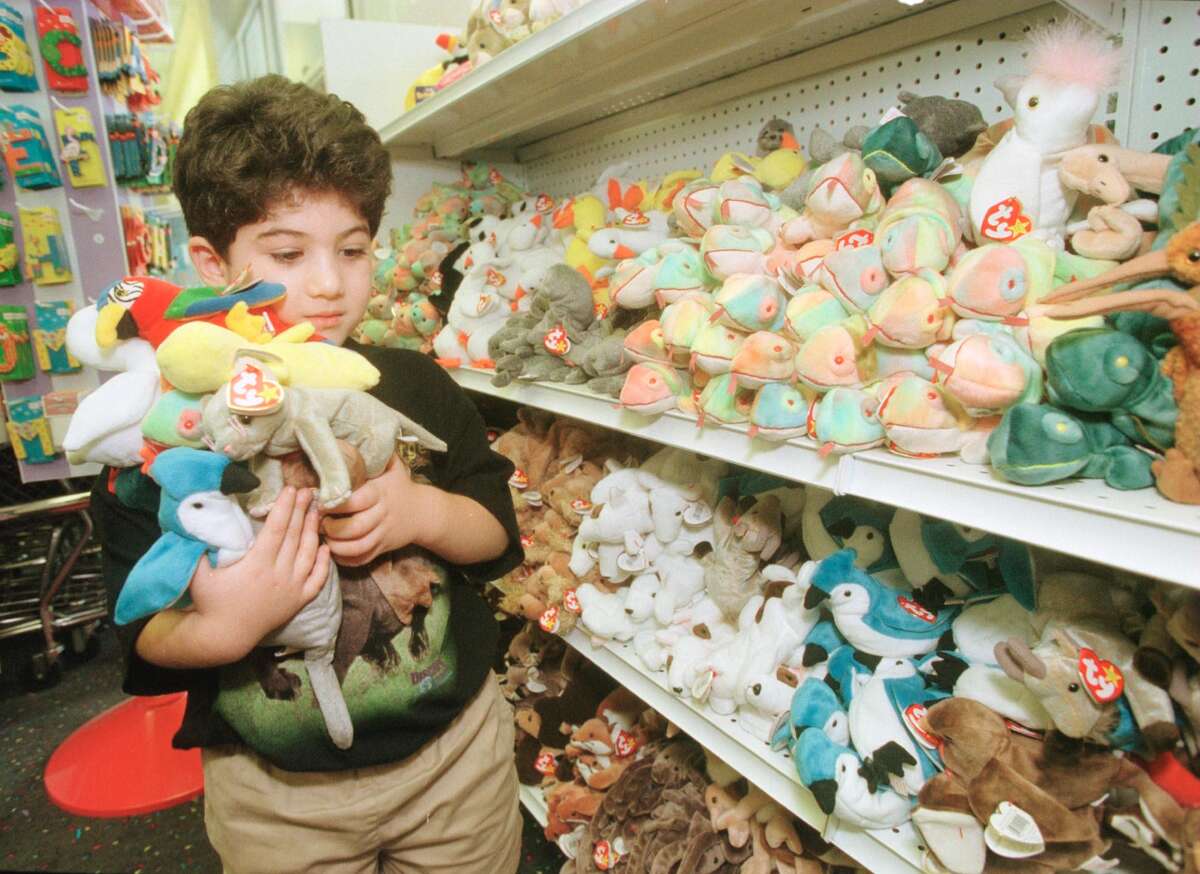Adam Kalina, 5, has his arms full of Beanie Babies while shopping with his mother at the Zany Brainy Toy Store in Brentwood, Mo., on Sept. 2, 1999. At the time, Ty, Inc. said it would retire the plush toys at the end of the year, resulting in customers swarming gift shops. This toy store reportedly allowed just 12 Beanie Babies to be purchased per customer. 