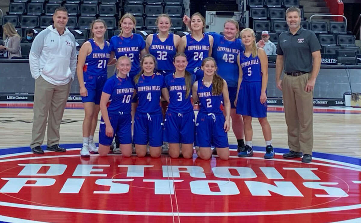 Chippewa Hills girls basketball players pose for pictures at center court of Little Caesars Arena in Detroit on Saturday after defeating Montabella 46-30.