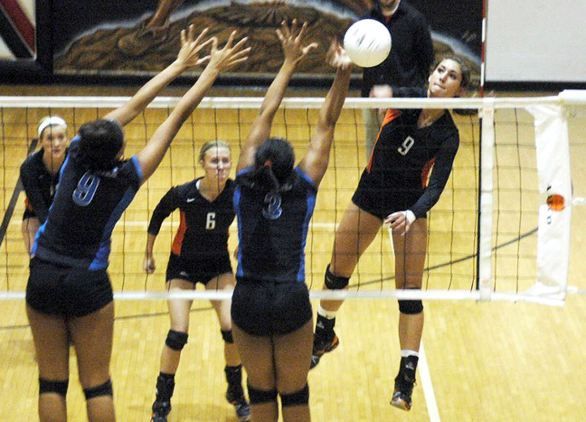 Edwardsville’s Sam Epenesa, right, hammers home a kill during the 2011 Class 4A Granite City Regional. 
