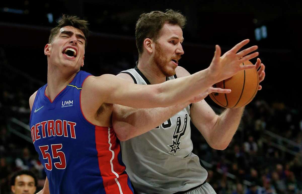 Spurs center Jakob Poeltl, right, grabs a rebound against Pistons center Luka Garza (55) during the first half Saturday, Jan. 1, 2022, in Detroit.