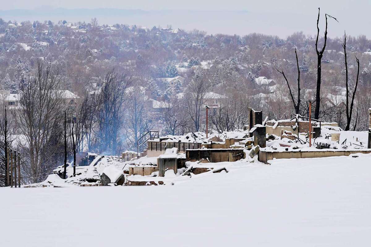 Snow covers the burned remains of homes in Louisville, Colo., on Saturday.