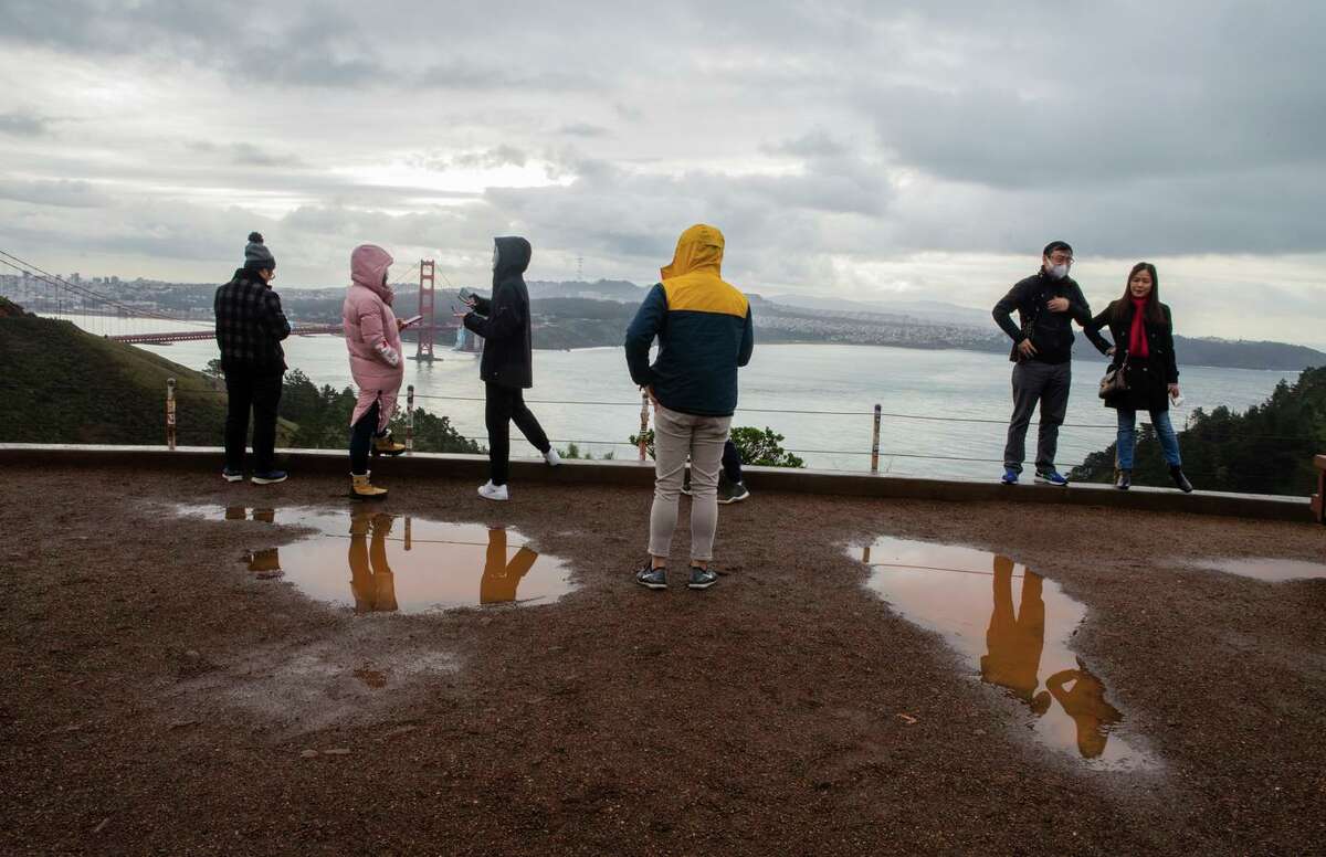 Tourists in the Marin Headlands look out over the Golden Gate Bridge on a rainy day in December. If the rest of the season is dry, experts say drought conditions will persist.