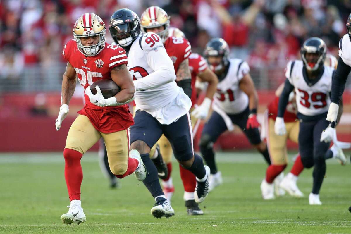 San Francisco 49ers' Elijah Mitchell outruns Houston Texans' Ross Blacklock during Mitchell's 37-yard run in 4th quarter during Niners' 23-7 win in NFL game at Levi's Stadium in Santa Clara, Calif., on Sunday, January 2, 2022.