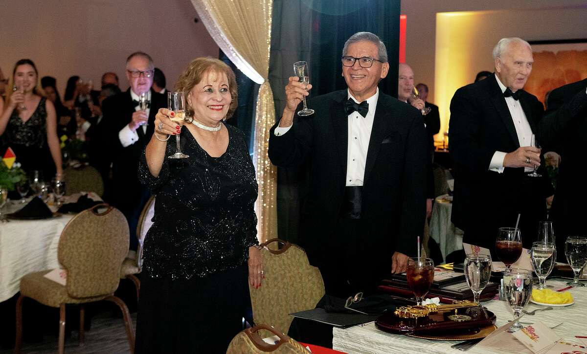 A room filled with friends and family raise a glass to toast Miguel Conchas, joined by his wife Cynthia Conchas, Saturday, July 24, 2021 at the Laredo Country Club during a celebration of Mr. Conchas's retirement.