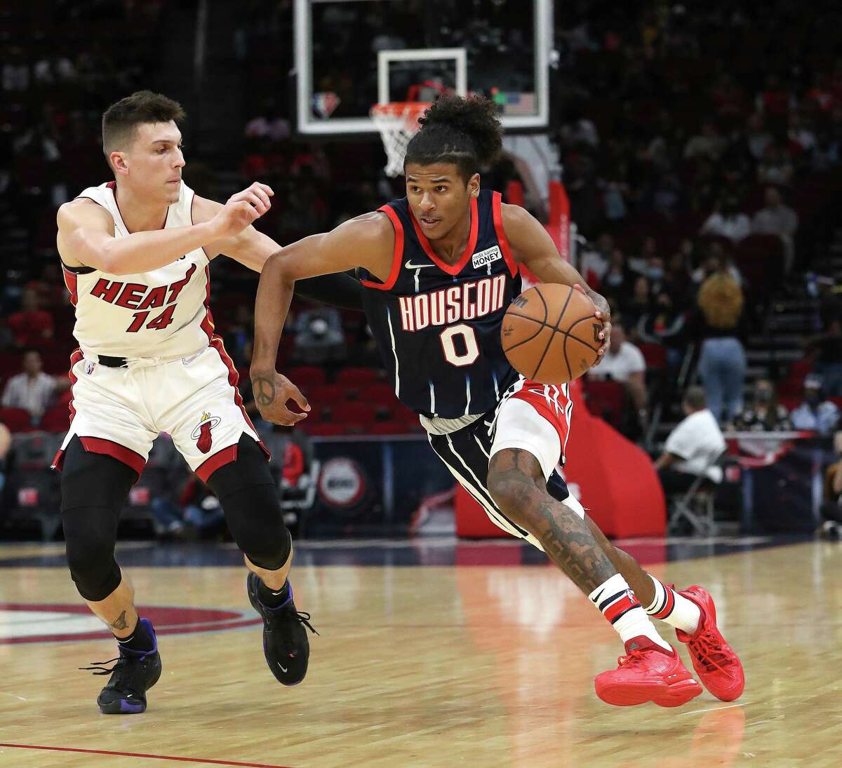 Houston Rockets goalie Jalen Green (0) walks past Miami Heat goalie Tyler Herro (14) during the first half of an NBA basketball game at Toyota Center on Friday, December 31, 2021 in Houston.