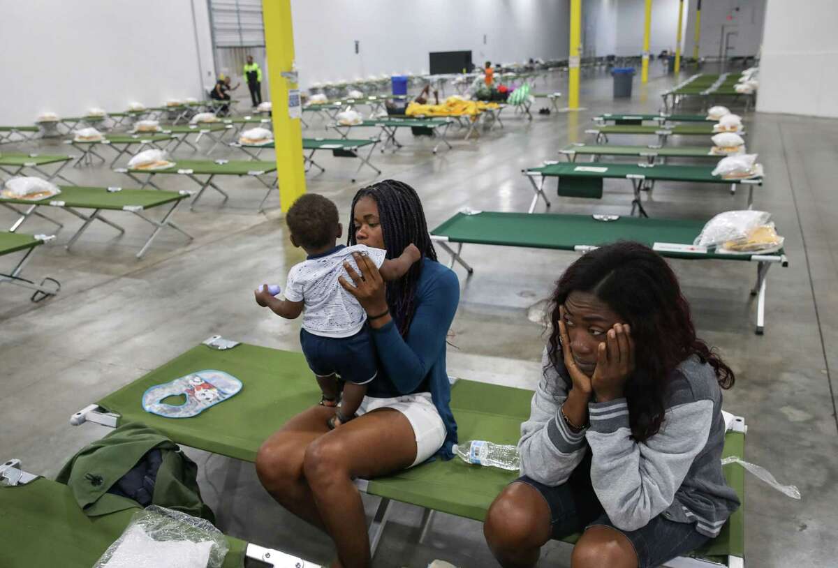 Vallerie Lamour, from right, Jouseline Metayer and her son Jayden Metayer, 7 months, sit on cots Saturday, June 5, 2021, at a shelter for migrants in Houston. The three are migrants from Haiti.