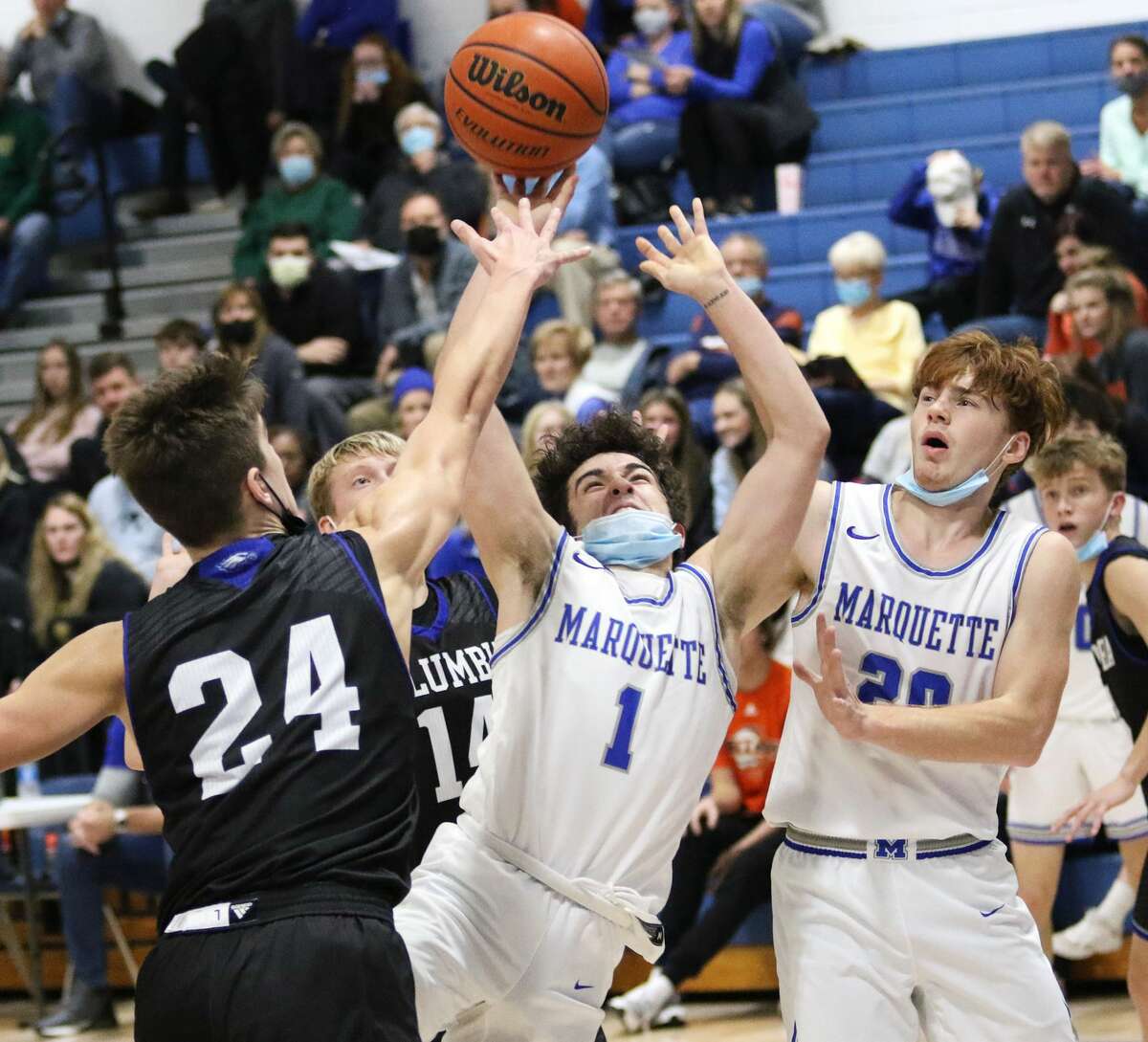 Marquette Catholic's Parker Macias (1) scores while drawing the foul from Columbia's Dylan Murphy (24) while the Explorers' Brody Hendricks watches the play in the title game of the Columbia-Freeburg Tournament last Wednesday in Columbia.
