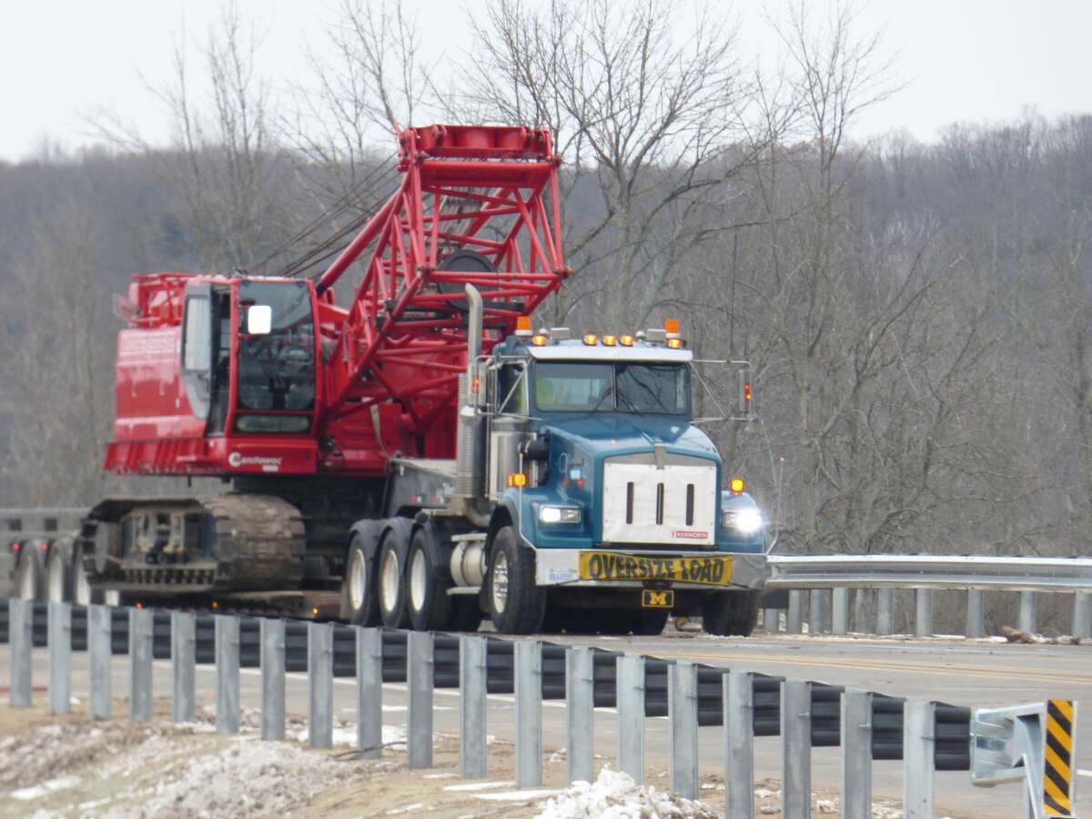 Construction equipment is loaded up for transportation following completion of the M-55 bridge project in Manistee Township.