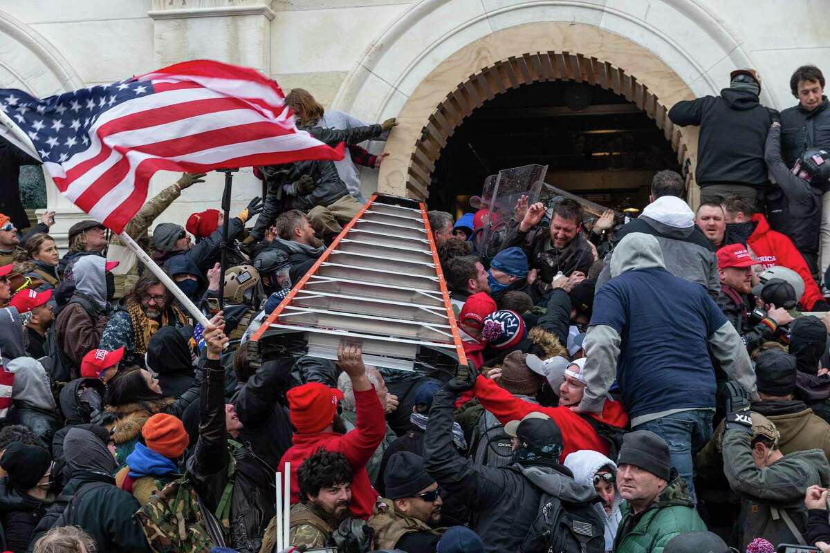 Insurrectionists clashing with police use a ladder to try to force entry into the Capitol on Jan. 6, 2021, in Washington, D.C. Rioters broke windows and breached the Capitol in an attempt to overthrow the results of the 2020 election. (Lev Radin/Pacific Press via ZUMA Wire/TNS)